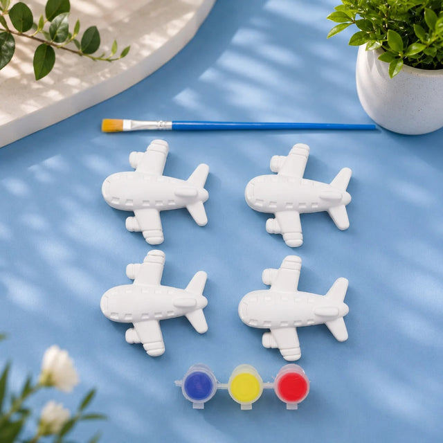 Aeroplane Set — 4 white Plaster of Paris planes with paint pots and brush on light blue background