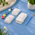 Toy Cars Set — 4 white Plaster of Paris cars with paint pots and brush on light blue background