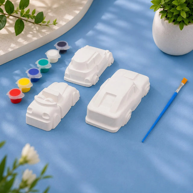 Toy Cars Set — 4 white Plaster of Paris cars with paint pots and brush on light blue background